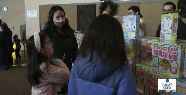 TOTE and Alaska Native families exchanging holiday gifts at a community event.