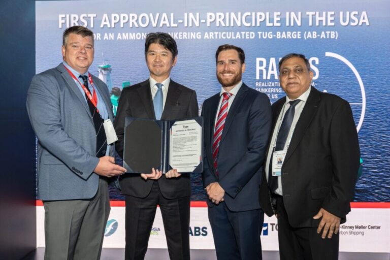 Four men in formal suits holding a certificate at a conference.