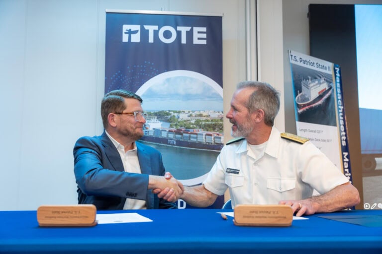 TOTE and Massachusetts Maritime Academy representatives shake hands during scholarship announcement.