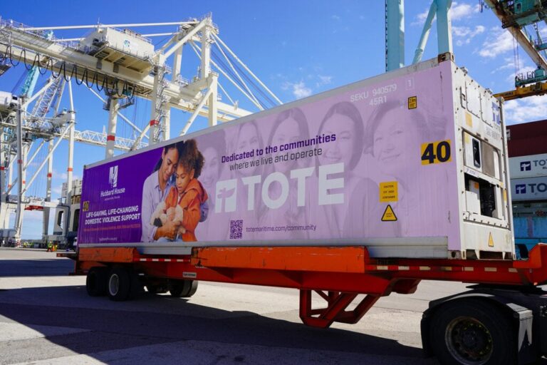 Shipping container with TOTE Maritime Puerto Rico branding at port.