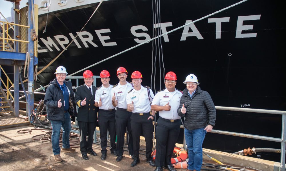 EMPIRE STATE ship with six crew members in safety helmets giving thumbs up.